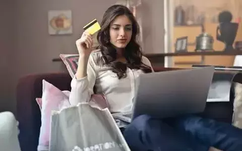 Woman sitting on couch shopping online