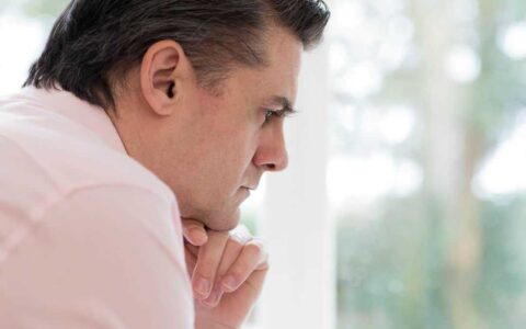 Profile view of worried man at home