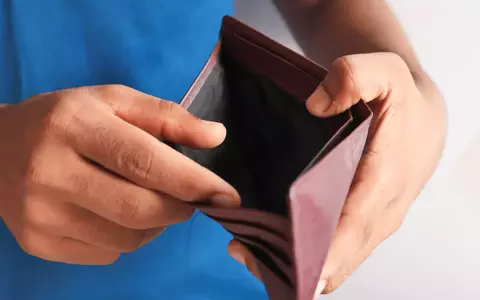 Individual looking at empty wallet