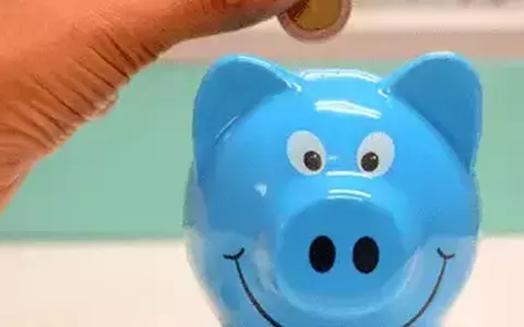 Smiling blue piggy bank with coins